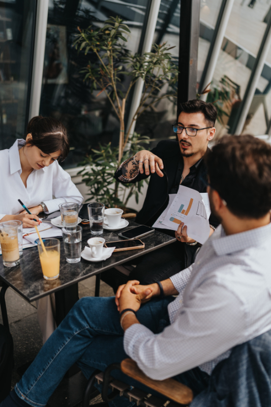 Team discussing business strategies during a casual outdoor meeting at a cafe photo of reliable local partners